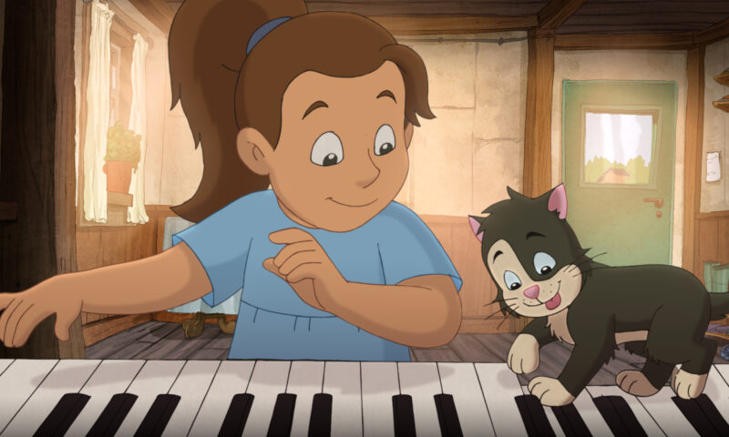 Dziewczynka i kotek przy klawiaturze fortepianu.