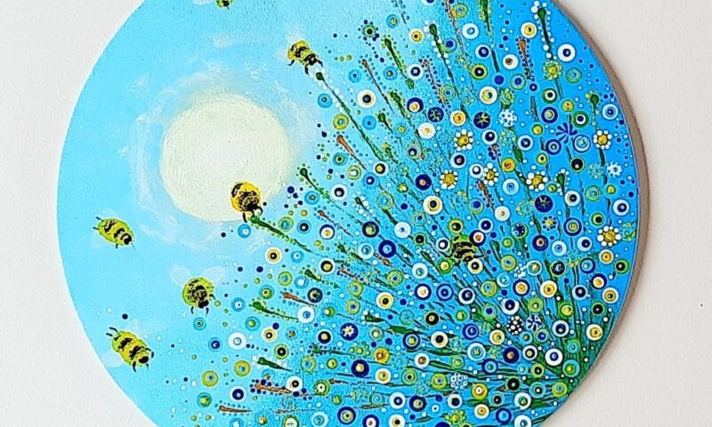 Niebieskie koło w pszczołami i kwiatami